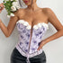 Woman in a lavender floral lace corset top with white flower trim and lace-up front, holding white roses.