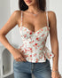 Woman wearing white floral bustier top with sweetheart neckline and flounce hem.