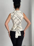 	Back view of sleeveless V neck blouse with waist tie and geometric print