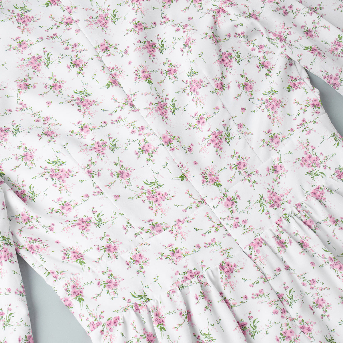 Seam stitching detail on floral print mini dress with gathered waist.