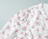 Shoulder seam and sleeve gathering detail on white dress with pink flowers