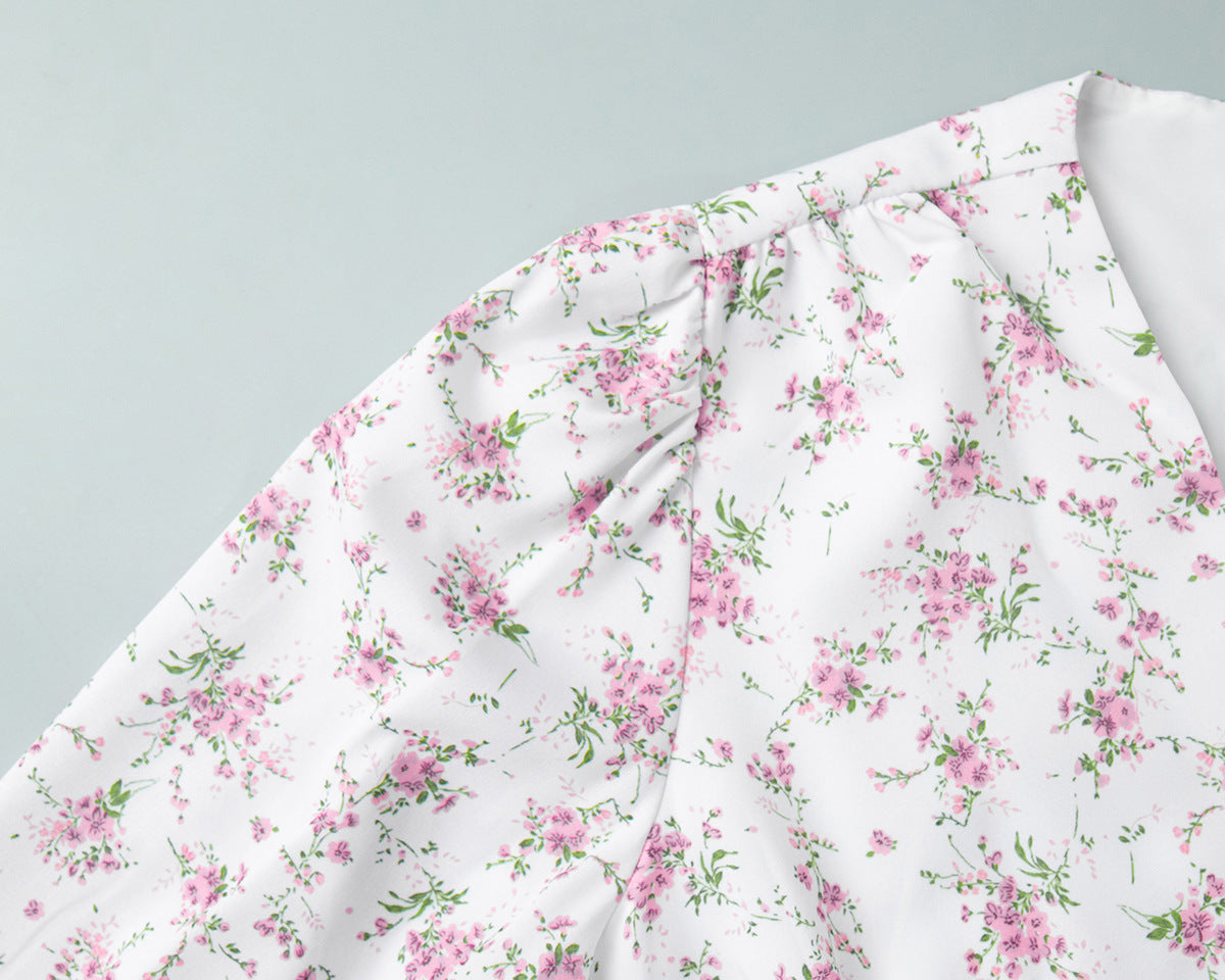Shoulder seam and sleeve gathering detail on white dress with pink flowers