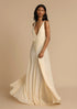 Woman wearing a white deep V vacation maxi dress with lace waist and flowing hem against a beige background