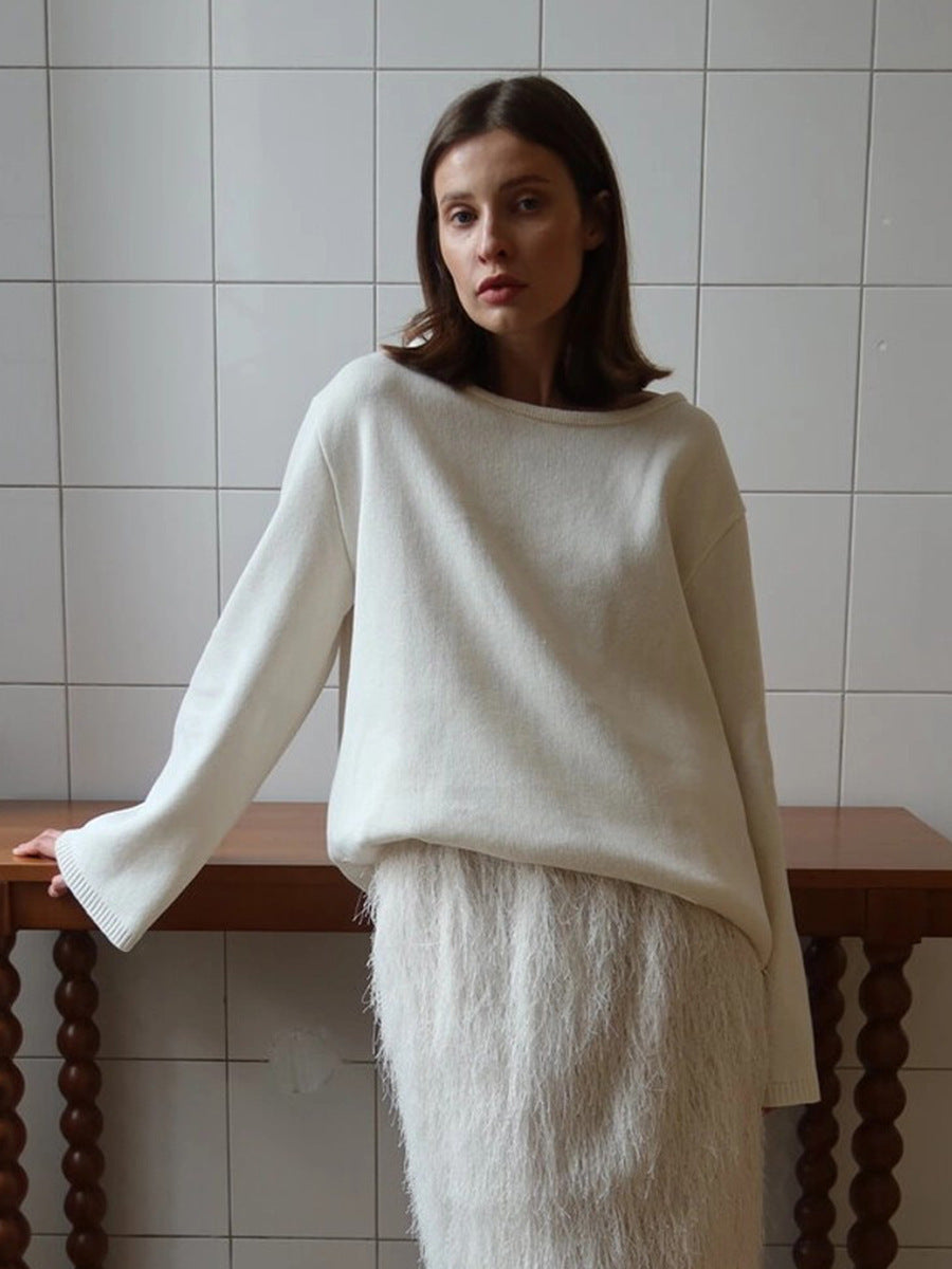 Woman styling white backless knit sweater with skirt indoors