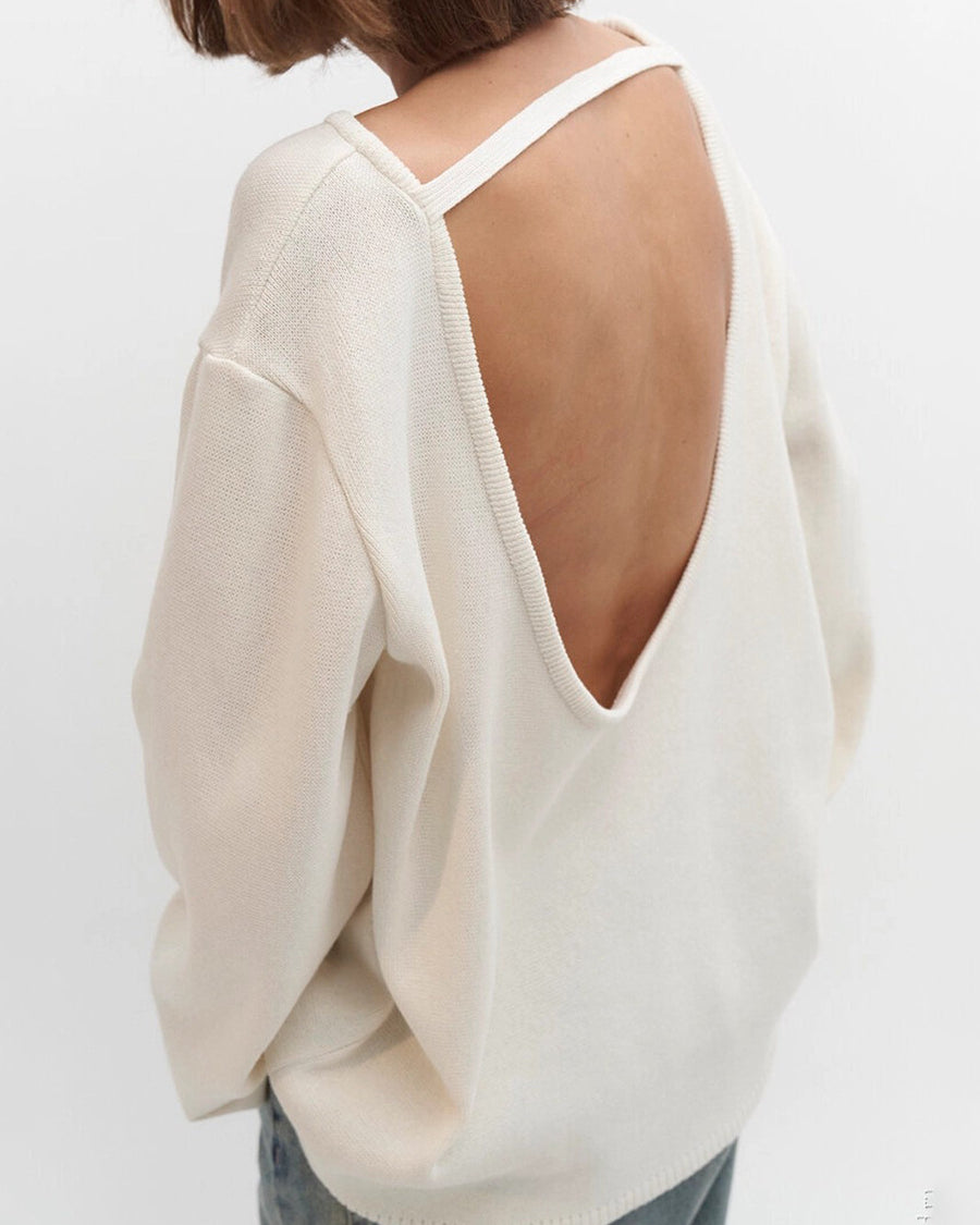 White sweater with open back worn by a person on a white background