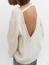 White sweater with open back worn by a person on a white background