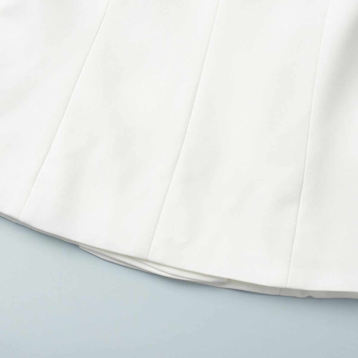Hemline and structure details of white blazer