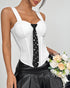White corset top with black pearl-accent tie styled with leather mini skirt, model holding cream rose bouquet.