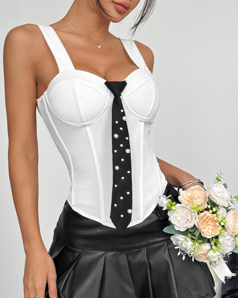 White corset top with black pearl-accent tie styled with leather mini skirt, model holding cream rose bouquet.