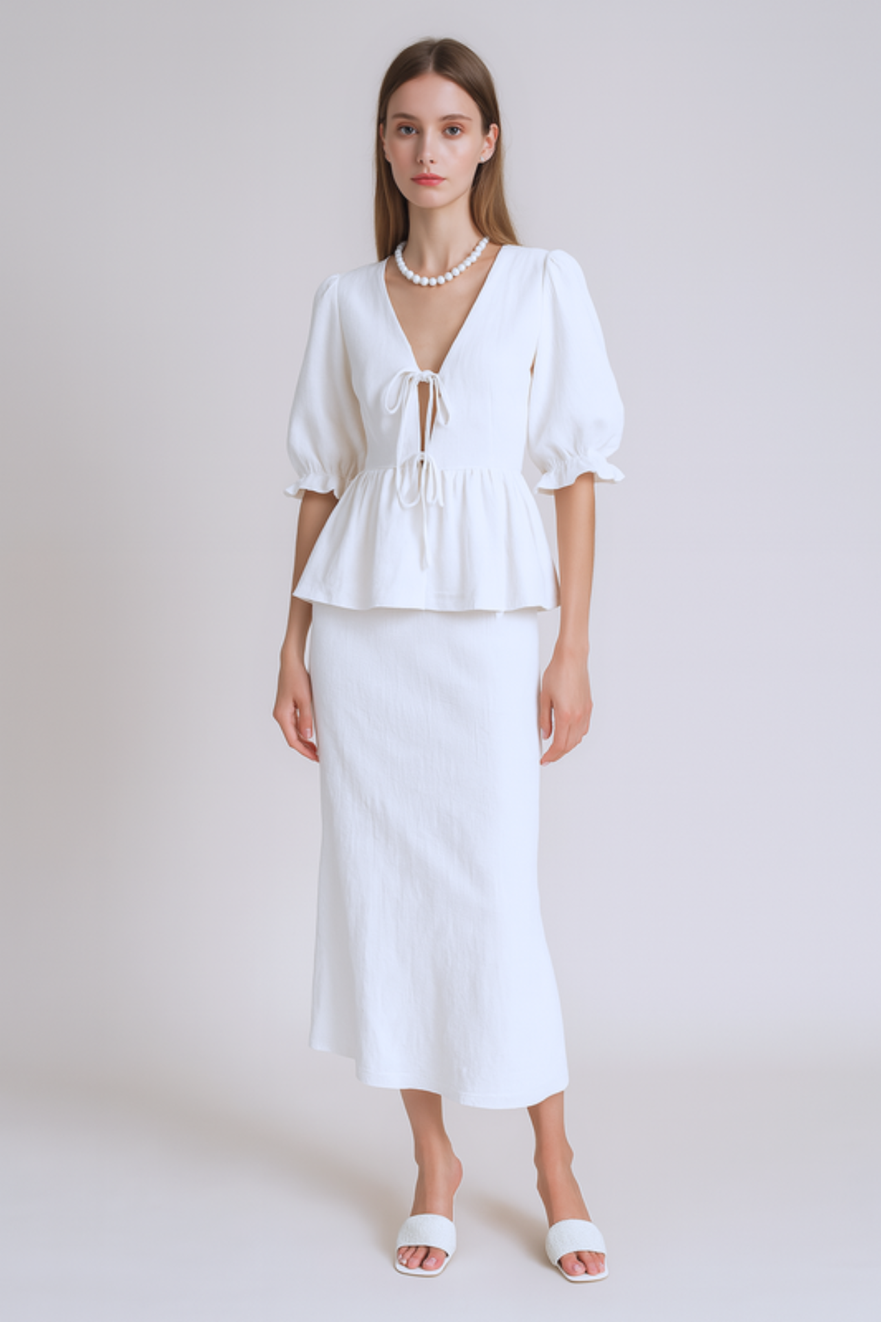 Woman wearing a white skirt set in a plain background