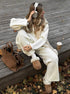 Relaxed sitting pose in white half zip sweater 2 piece set