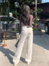Back view of white straight-leg jeans with textured patch pocket and high-rise waist.