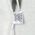 Inner care label tag of white knit sweater with fabric information
