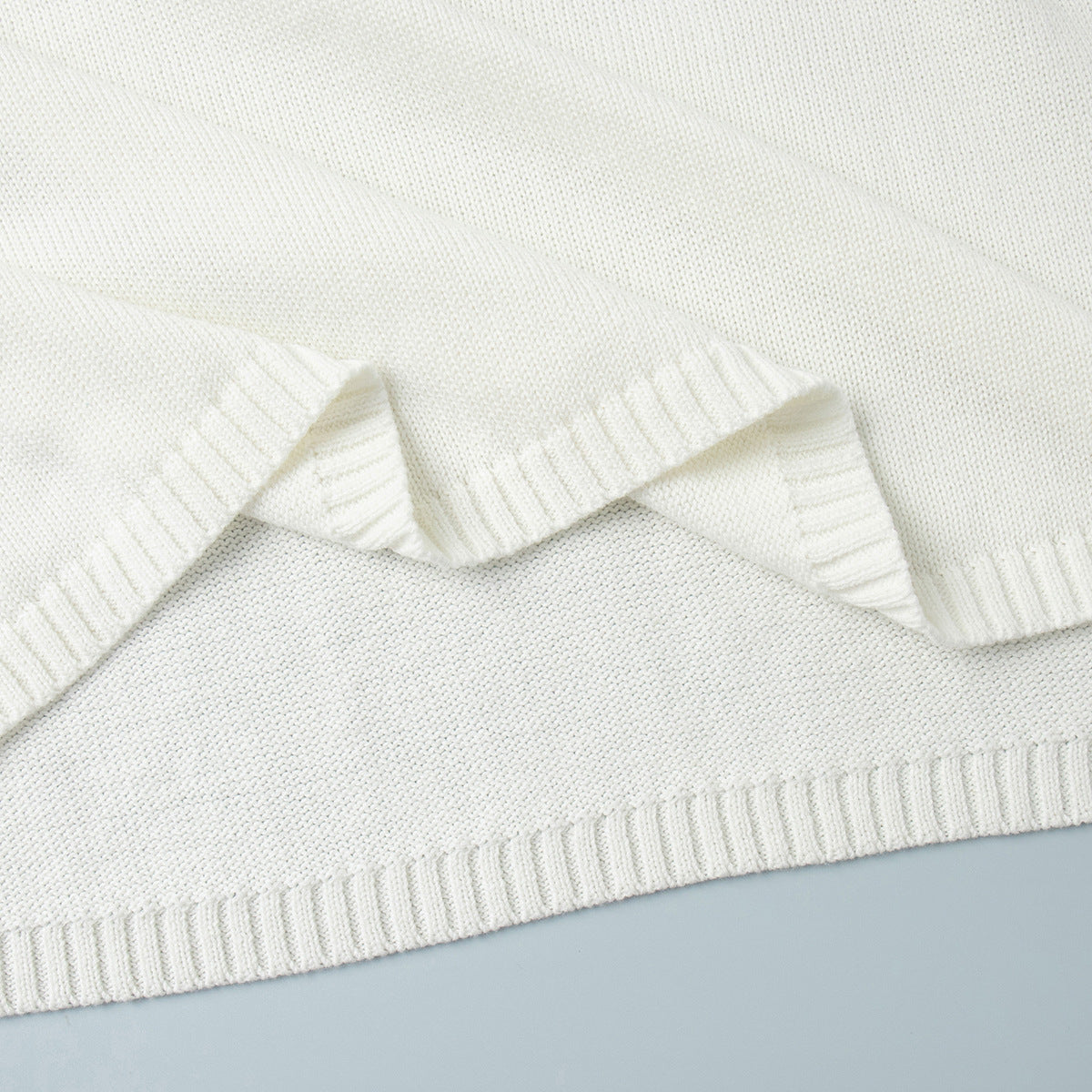 Close-up seam and stitching on white knit sweater