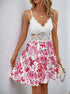 Front view of white lace floral dress with cutouts and pink floral print.