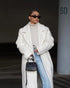 White long teddy coat with sunglasses, relaxed winter styling
