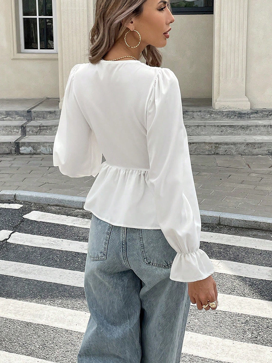 Back view of white puff sleeve blouse with flared cuffs