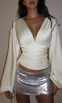 White satin long sleeve top with ruched waist and deep V-neck