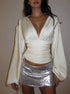 White satin long sleeve top with ruched waist and deep V-neck