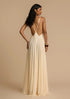 Back view of woman wearing a white v-neck maxi dress with a open back on a beige background