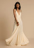 Woman in white deep V vacation maxi dress with lace waist and flowing hem.