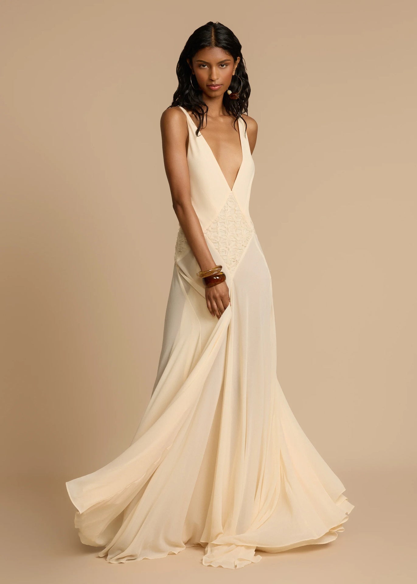 Woman in white deep V vacation maxi dress with lace waist and flowing hem.