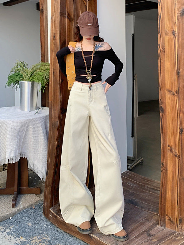 Front view of white wide-leg jeans paired with black long-sleeve top and gold chain necklace.
