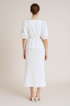 Woman wearing a white set with a plain background