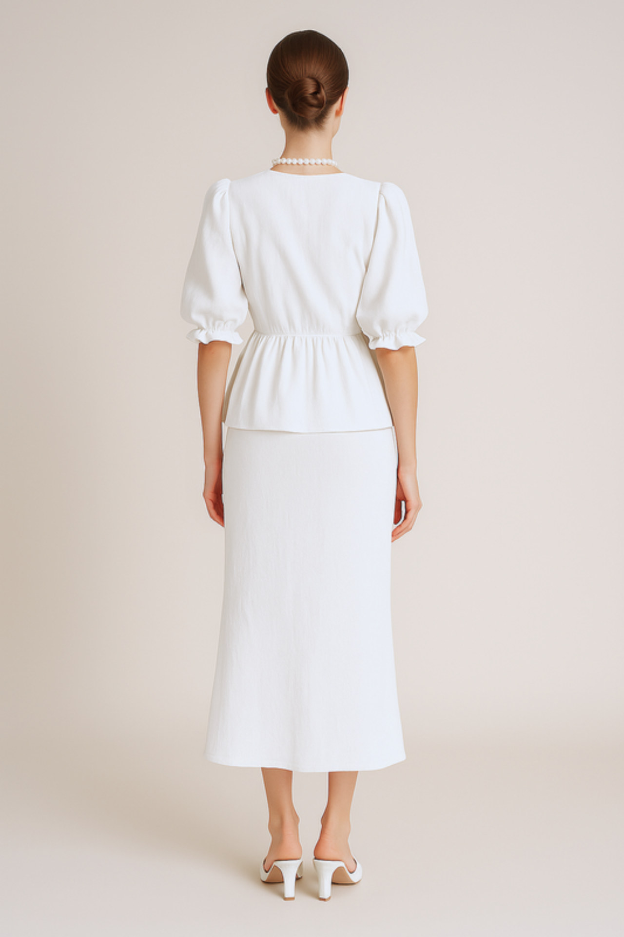 Woman wearing a white set with a plain background