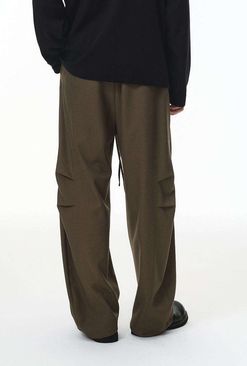 Dark khaki wide-leg trousers with drawstring waist, relaxed streetwear pants