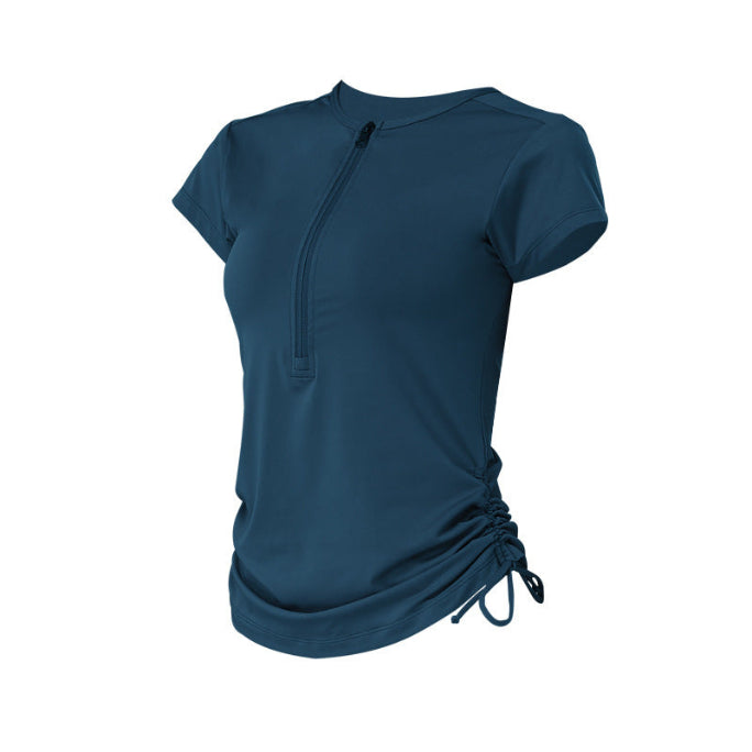 Dark blue athletic top on white background, showing side ruched detail and front zip.