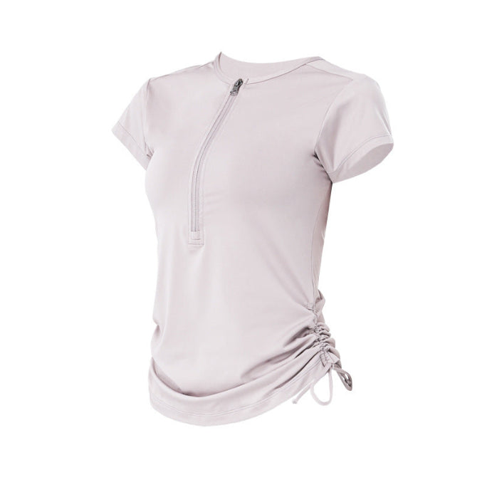 Light pink athletic top on white background, showing side ruched detail and front zip.
