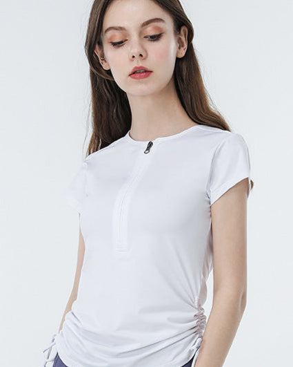 Model wears white athletic top with zip-up front and side ruching.