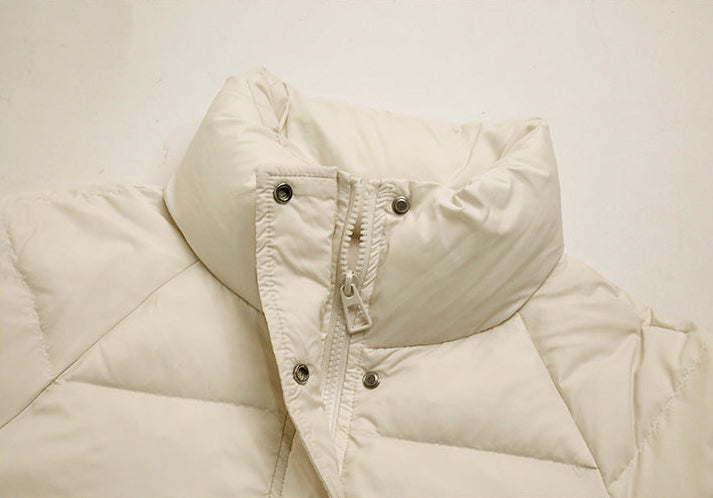 High collar and zipper detail of women’s cream long puffer coat