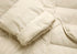 Cuff and sleeve detail of cream women’s long quilted puffer coat