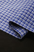 Close-up of blue plaid fabric detail on women’s layered long sleeve polo shirt, preppy school fashion
