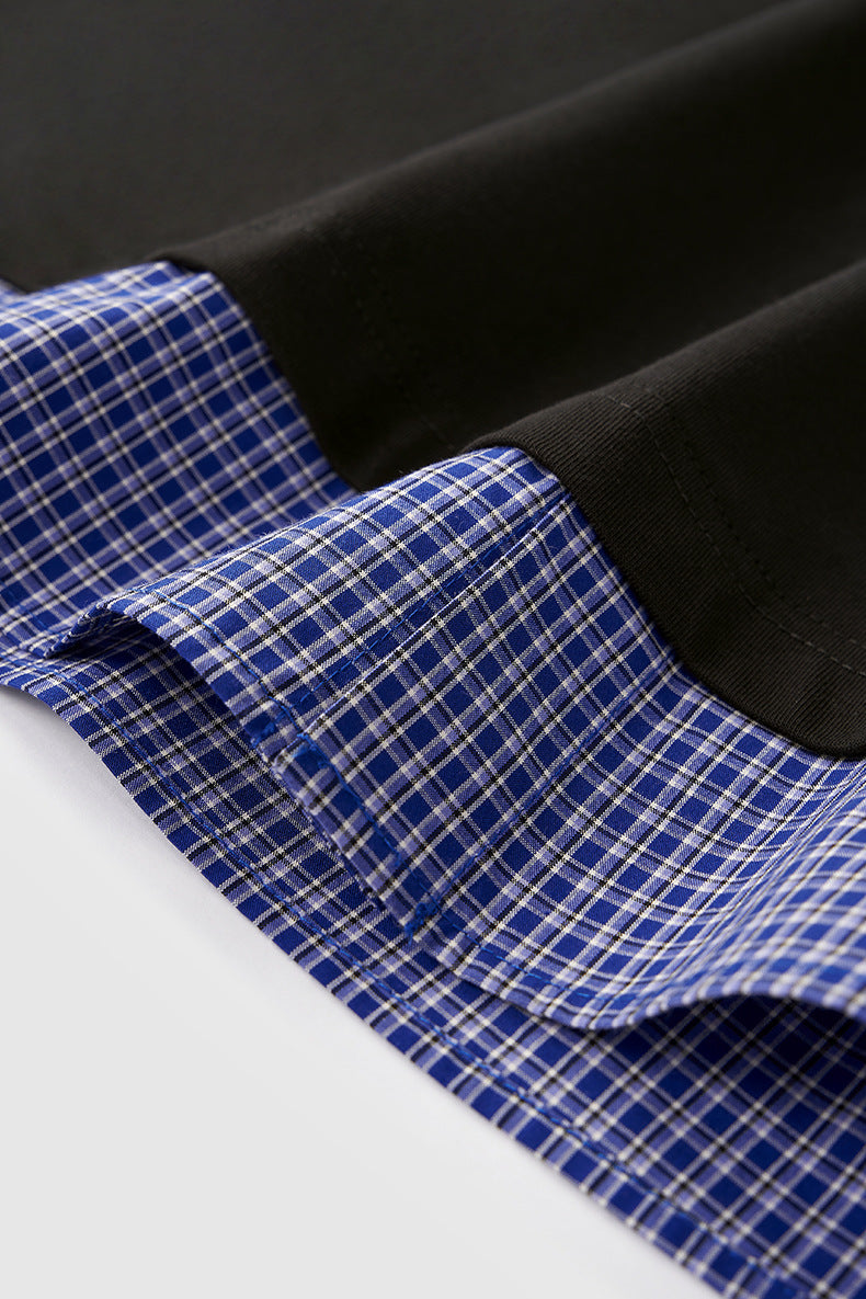 Close-up of hem detail on women’s layered long sleeve polo shirt with plaid sleeves, casual streetwear top