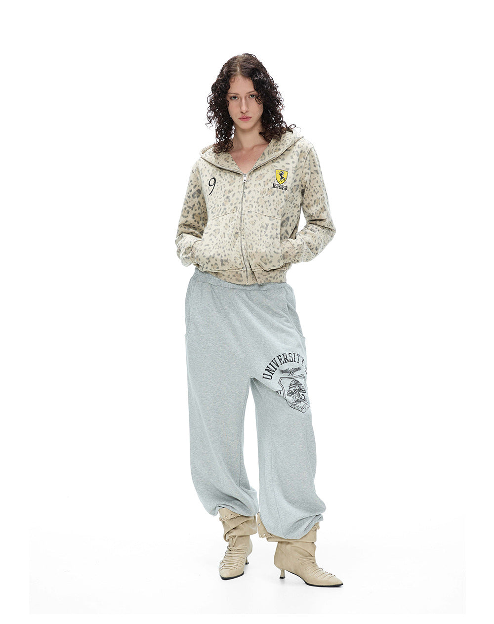 Front full body view of a model styled in a leopard print cropped zip hoodie and casual sweatpants.