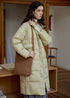 Light green long puffer coat for women with brown shoulder bag and high collar