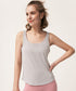 Woman smiling in a light gray tank top and pink leggings with text overlay above.