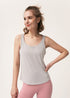 Woman posing in a light gray racerback tank top and pink leggings.