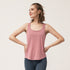 Woman posing with hands on hips in a dusty pink tank top and navy leggings.