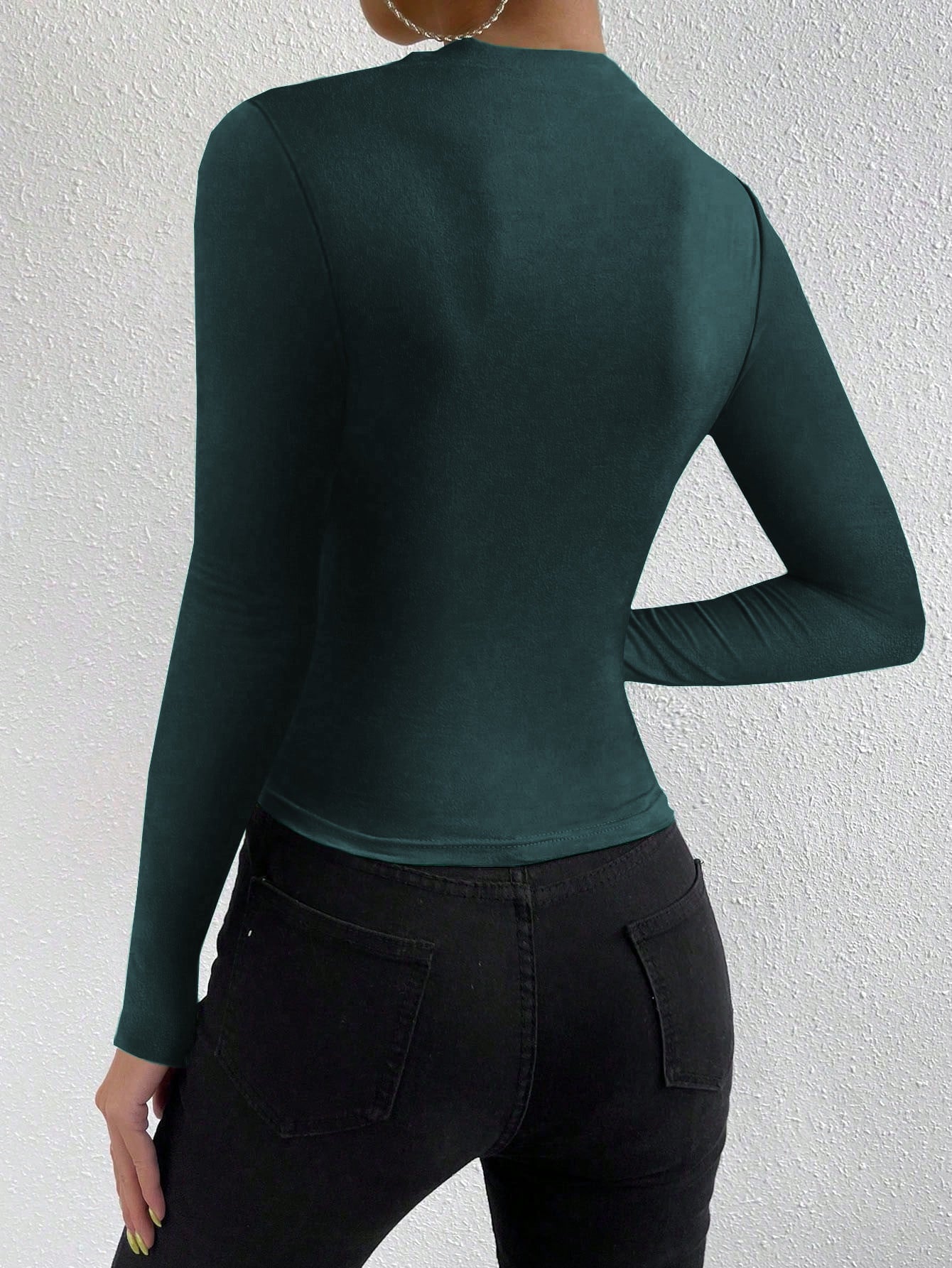 back view, slim fit green knit long sleeve top, clean waist and fitted sleeves