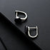 Pair of silver stud earrings with round black stone on dark surface.