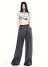 Woman wearing gray high waist pleated wide-leg pants with belt.