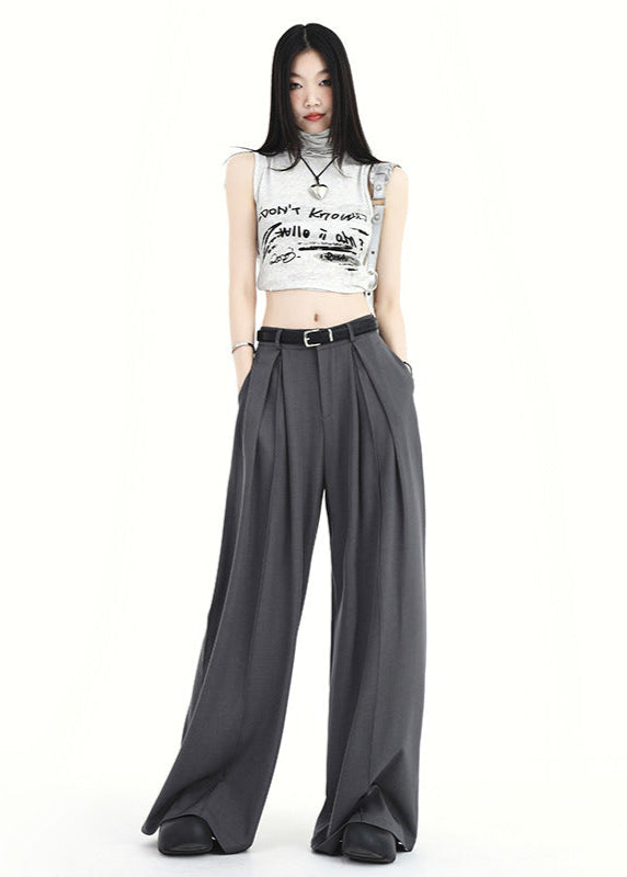 Woman wearing gray high waist pleated wide-leg pants with belt.
