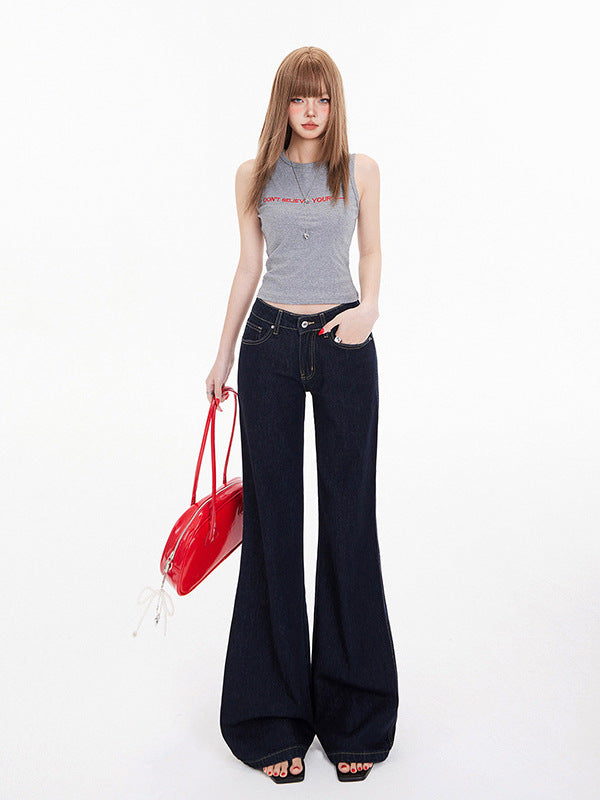 Low rise bootcut jeans in deep blue denim, styled with grey crop top and red patent handbag