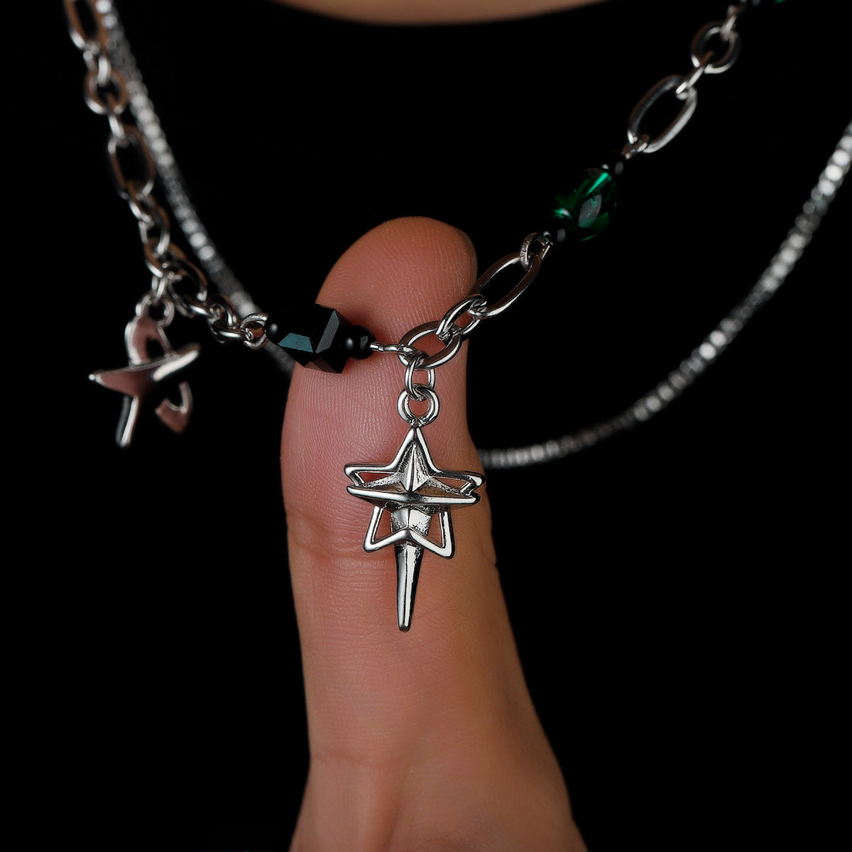 Star charm pendant resting on a finger, showing detailed shape and finish.