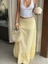 Yellow high waisted ruffle skirt in motion with beach-style accessories