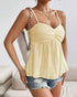 Woman wearing smocked yellow tank top with spaghetti straps and flared hem